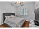 Comfortable bedroom featuring a ceiling fan, window with blinds, and hardwood flooring at 9362 Wilderness Glen Ave, Las Vegas, NV 89178