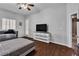 This bedroom features wood floors, a bed, a daybed, TV and fan at 9362 Wilderness Glen Ave, Las Vegas, NV 89178