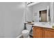 Half bath with light fixtures, small plants, mirror, toilet, and vanity sink with cabinet storage at 9362 Wilderness Glen Ave, Las Vegas, NV 89178