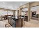 Open kitchen featuring a central island, dark cabinetry, and a view into the dining and living areas at 9362 Wilderness Glen Ave, Las Vegas, NV 89178