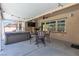 Undercover patio features a hot tub, ceiling fan, a TV and furniture, providing a comfortable and inviting outdoor living space at 9362 Wilderness Glen Ave, Las Vegas, NV 89178