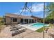 Inviting pool with lounge chairs on a sunny day surrounded by landscaped yard and a covered patio with seating area at 9362 Wilderness Glen Ave, Las Vegas, NV 89178
