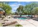 Beautiful community pool and hot tub area with lounge chairs, tables and mature landscaping creating a relaxing atmosphere at 9362 Wilderness Glen Ave, Las Vegas, NV 89178
