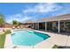 Resort-style backyard featuring a sparkling pool, lounge chairs and covered patio with comfortable seating area at 9362 Wilderness Glen Ave, Las Vegas, NV 89178