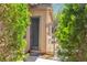 Charming side entrance featuring a privacy gate, Welcome mat, and trimmed green shrubs at 9362 Wilderness Glen Ave, Las Vegas, NV 89178
