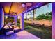 Inviting covered back patio featuring ceiling fans, lounge seating, and a well-maintained lawn at 9704 Royal Lamb Dr, Las Vegas, NV 89145