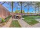 The landscaped backyard features a patio with dining set, a brick-lined walkway, and a vibrant green lawn at 9704 Royal Lamb Dr, Las Vegas, NV 89145