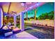 Cozy outdoor patio with ceiling fans, string lights, and seating area overlooking the green lawn at 9704 Royal Lamb Dr, Las Vegas, NV 89145