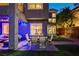 An outdoor patio is lit up with blue lights and a dining set at 9704 Royal Lamb Dr, Las Vegas, NV 89145