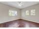 View of a bedroom with wood floors and three large windows offering natural light at 9704 Royal Lamb Dr, Las Vegas, NV 89145