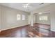 A bright bedroom with wood floors, ceiling fan, and view from the windows at 9704 Royal Lamb Dr, Las Vegas, NV 89145