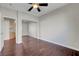 A clean bedroom with wood floors, ceiling fan, and mirrored closet doors offers space with practical closet solutions at 9704 Royal Lamb Dr, Las Vegas, NV 89145