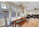 Sunlit dining area with wood floors, rustic table, and large windows offering views at 9704 Royal Lamb Dr, Las Vegas, NV 89145