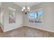 Light-filled dining room with wood-look tile floors and large windows offering pleasant backyard views at 9704 Royal Lamb Dr, Las Vegas, NV 89145