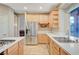 Bright kitchen features stainless appliances, island cooktop, natural wood cabinets, and a large window at 9704 Royal Lamb Dr, Las Vegas, NV 89145