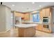 Bright kitchen boasts stainless appliances, double oven, island cooktop, and natural wood cabinetry at 9704 Royal Lamb Dr, Las Vegas, NV 89145