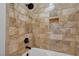 The shower area features decorative stone tiling, a niche for storage, and a relaxing bathing experience at 9704 Royal Lamb Dr, Las Vegas, NV 89145