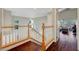 Upstairs hallway with hardwood floors and white railings, providing a view of the downstairs living areas at 9704 Royal Lamb Dr, Las Vegas, NV 89145