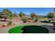 Expansive backyard with putting green and views of the lush desert golf course at 10100 Folsom Dr, Las Vegas, NV 89134