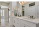 Bright bathroom featuring double sinks, a large mirror, and a doorway to a glass-enclosed shower at 10100 Folsom Dr, Las Vegas, NV 89134