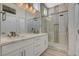 Modern bathroom showcasing double sinks, white cabinetry, and a glass-enclosed shower with unique tile accents at 10100 Folsom Dr, Las Vegas, NV 89134