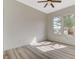 Bright bedroom featuring light wood floors, neutral walls, and windows with a view of palm trees at 10100 Folsom Dr, Las Vegas, NV 89134