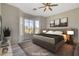 Bedroom with a large bed, bay windows, ceiling fan, and hardwood-style floors at 10100 Folsom Dr, Las Vegas, NV 89134