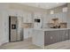 Elegant kitchen with stainless steel refrigerator, white cabinets, and sleek marble countertops, creating a clean and modern aesthetic at 10100 Folsom Dr, Las Vegas, NV 89134