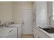 Bright laundry room featuring new appliances, white cabinets, and a utility sink with modern fixtures at 10100 Folsom Dr, Las Vegas, NV 89134