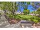 Scenic view of community grounds from pathway with wrought iron bench overlooking manicured lawn and mature trees at 10109 Jacob Pl # 203, Las Vegas, NV 89144