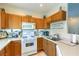 Cozy kitchen features oak cabinets, white appliances, and laminate countertops for a functional cooking space at 10109 Jacob Pl # 203, Las Vegas, NV 89144