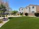 A beautifully landscaped common area with lush green turf and well-maintained shrubs at 10230 Viterbo St, Las Vegas, NV 89183