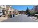 A quiet residential street lined with townhomes and blue recycling bins at 10230 Viterbo St, Las Vegas, NV 89183
