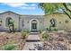 Charming home exterior with an arched entryway, desert landscaping, and stone pathway at 10277 Roma Madre Ave, Las Vegas, NV 89135