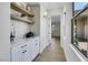 Bright hallway with white cabinetry, open shelves, and a large window at 10277 Roma Madre Ave, Las Vegas, NV 89135