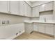 Bright laundry room features clean white cabinets, countertop, and modern flooring at 10277 Roma Madre Ave, Las Vegas, NV 89135