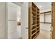 Large walk-in closet with custom shelving and dressing area leading to ensuite bathroom at 10277 Roma Madre Ave, Las Vegas, NV 89135