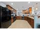 Well-lit kitchen featuring stainless steel appliances, tile floors, and dark wood cabinets offering ample storage at 10440 Bay Ginger Ln, Las Vegas, NV 89135