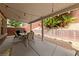 Covered patio space featuring a dining table set, surrounded by desert landscaping with palm trees and block wall at 10440 Bay Ginger Ln, Las Vegas, NV 89135