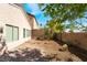 Fenced backyard with gravel landscaping, brick patio, mature trees, and serene outdoor living space at 10458 Gabaldon St, Las Vegas, NV 89141