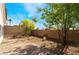 A gravel backyard with mature trees and shrubbery, providing a private and peaceful outdoor space at 10458 Gabaldon St, Las Vegas, NV 89141