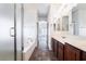 A bathroom showcasing a walk-in shower, soaking tub, double sinks and tile flooring at 10458 Gabaldon St, Las Vegas, NV 89141