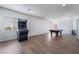 A spacious game room includes a pool table, arcade machine, wood-look flooring and natural light at 10458 Gabaldon St, Las Vegas, NV 89141