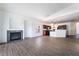 Open-concept living room and kitchen feature hardwood floors and a modern fireplace with tile surround at 10458 Gabaldon St, Las Vegas, NV 89141