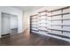 Spacious walk-in closet with wood-look flooring and custom built-in shelving system for optimal storage solutions at 10458 Gabaldon St, Las Vegas, NV 89141
