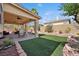 Spacious covered patio with ceiling fans and comfortable seating, overlooking the artificial turf backyard at 10948 Carberry Hill St, Las Vegas, NV 89141