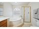 Bright bathroom featuring a large soaking tub with glass block window and separate glass enclosed shower at 10948 Carberry Hill St, Las Vegas, NV 89141