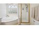 Bathroom features a soaking tub, glass block window, and glass enclosed shower at 10948 Carberry Hill St, Las Vegas, NV 89141