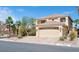 Two-story home with a large front yard, desert landscaping, and an attached two-car garage at 10948 Carberry Hill St, Las Vegas, NV 89141