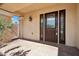 Front door featuring glass windows and a tile front porch, columns, and a wall with green plants at 10948 Carberry Hill St, Las Vegas, NV 89141